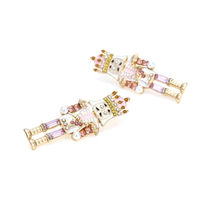 Détails macro des boucles d'oreilles casse-noisette avec émail et strass colorés