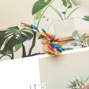 Detail of wing-shaped earring with colorful rhinestones and gold-plated alloy base