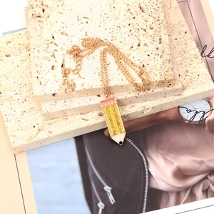 Collana con ciondolo a matita d'oro con strass gialli su eleganti lastre di pietra beige