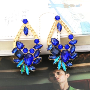 Close-up of teardrop drop earrings featuring blue and green floral crystal clusters