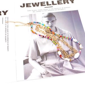 Collier bohème multicouche avec perles colorées, chaînes dorées et perles baroques