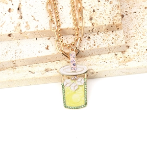 Dettaglio della collana a doppio strato dorata con un ciondolo colorato a forma di frappè