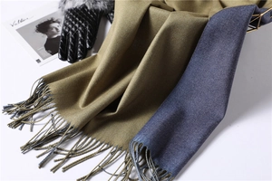 Detail of two-tone olive green and navy scarf with fringe and fine twill texture