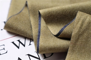 Macro detail of mustard green pashmina scarf showing twill texture and blue contrast edge