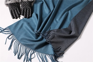 Detailed texture of two-tone navy and grey cashmere scarf with elegant fringe edges