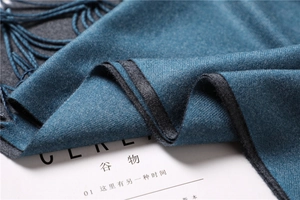 Detailed close-up of double-sided cashmere-like scarf with fringe and fine twill texture