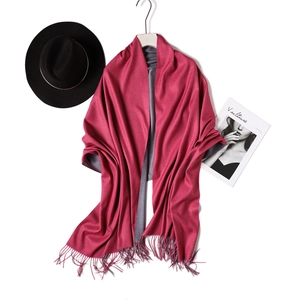 Close-up of burgundy and grey reversible scarf with fringe edge and autumn styling props