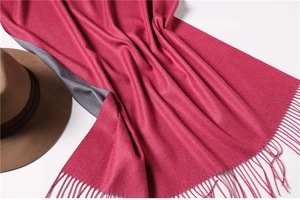 Detail of rose red and dark grey double-sided cashmere-like scarf with fringe tassels