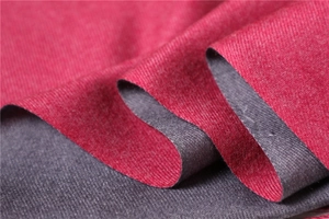 Macro detail of soft red and grey cashmere-like scarf showing twill texture and fabric weave