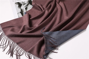 Detail of double-sided cashmere scarf with wine red and blue-grey tones and fringe edges