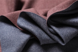 Macro detail of soft cashmere-like scarf showing burgundy and grey-blue knit texture