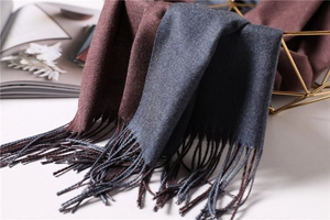 Detailed close-up of double-sided cashmere-like scarf with fringe and soft knit texture