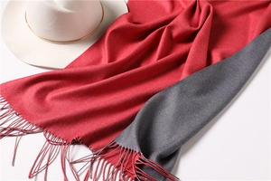 Detail of red and gray double-sided cashmere-like scarf with long fringe and elegant drape