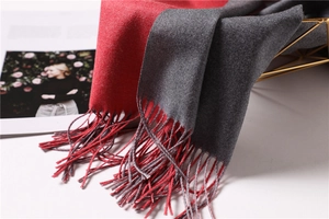 Detail of red and grey double-sided cashmere-like scarf with fringe on a metal basket