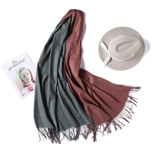 Detail of double-sided cashmere scarf in dark green and rust red with fringe tassels