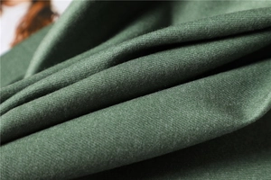Macro detail of dark green twill cashmere-like fabric with a soft brushed texture