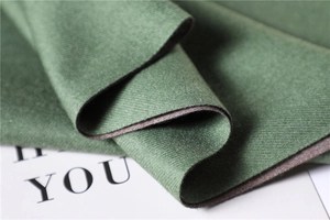 Detail of forest green and gray-purple double-sided scarf with twill woven texture