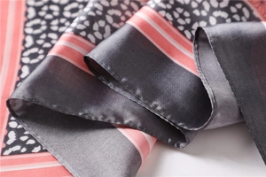 Détail macro du foulard en soie avec imprimé léopard et texture satinée lisse