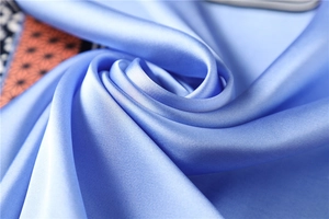 Gros plan du tissu en soie bleu clair avec texture lisse et éclat satiné luxueux