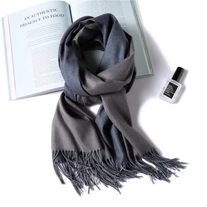 Detail of navy blue and dark grey cashmere scarf with fine tassels and soft texture