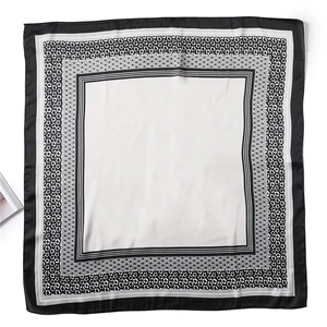 Vue détaillée de dessus d'un foulard carré en soie noir et blanc avec bordure léopard