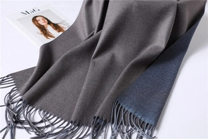 Close-up of double-sided cashmere-like scarf with fringe detail in brown and navy blue