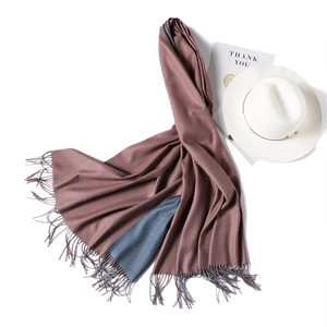 Detail of double-sided cashmere-like scarf in dusty pink and navy with fine tassels
