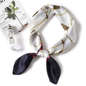 Detail of silk scarf with gold chain and rope patterns in black and white contrast