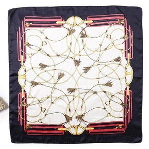 Flat lay of a silk square scarf featuring gold equestrian chains and navy blue borders