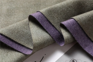 Detail of soft double-sided cashmere-like fabric in olive green and dark purple