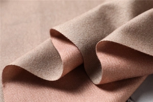 Macro shot of double-sided cashmere-like scarf showing twill texture in camel and pink