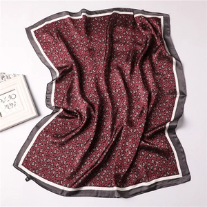 Detailed view of red leopard print silk satin scarf with grey and white stitched edges