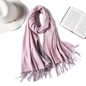 Detail of pink double-sided cashmere-like scarf with fringe and cozy lifestyle props