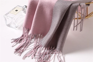 Close-up of pink and grey cashmere-like scarf showing soft texture and tassels