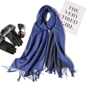 Flat lay of navy cashmere-like scarf with tassels, quilted leather gloves and sunglasses