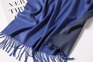 Detail of soft double-sided cashmere-like scarf with fringe edges and twill texture