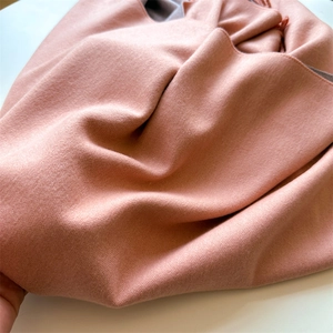 Macro view of light pink knit scarf showing soft cashmere-like texture and fine weaving