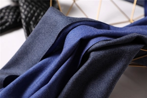 Close-up of double-sided cashmere scarf showing dark blue and royal blue fabric texture