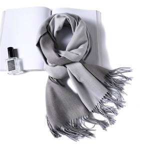 Detail of grey ombre faux cashmere scarf with tassels on white background
