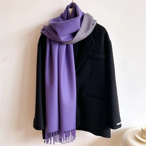 Detail of purple and grey cashmere-feel scarf with fringe tassels on black wool coat