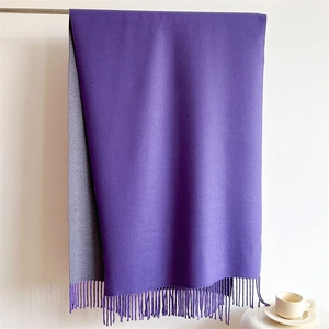 Close-up of thick dual-tone scarf in dark purple and light grey with tassel details