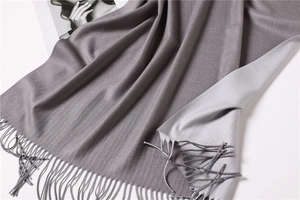 Detail of double-sided cashmere-like scarf with fringe edges in grey twill texture