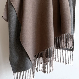 Detail of soft cashmere-like scarf with bicolor brown and grey fringe design
