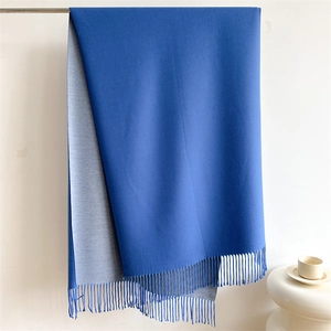 Detail of royal blue and grey double-sided scarf with elegant hand-rolled tassels