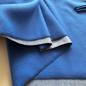 Close-up of thick double-sided cashmere scarf in navy blue and grey with fringe detail