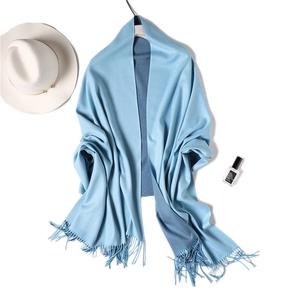 Detail of light blue cashmere-feel shawl showing soft fringe edges and double-sided texture