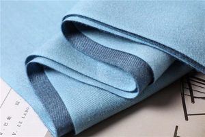 Macro shot of sky blue cashmere-feel scarf showing fine twill weave and soft texture