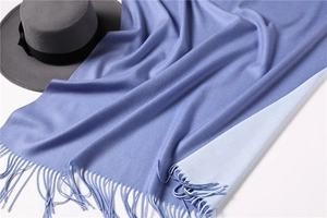 Detail of two-tone lavender cashmere feel scarf with fringe trim and knitted texture