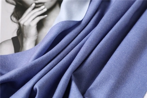 Close-up of soft purple-blue cashmere shawl texture with elegant natural fabric folds