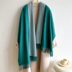 Detail of double-sided two-tone scarf with dark green and grey colors and fringe